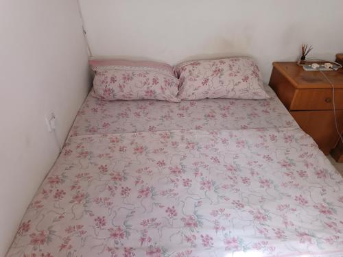 a bedroom with a bed with a pink floral bedspread at House of character that Quest will like . in Ħal Balzan