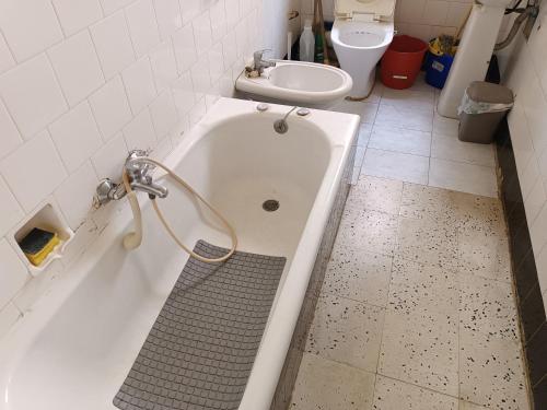 a bathroom with a tub and a sink and a toilet at House of character that Quest will like . in Ħal Balzan