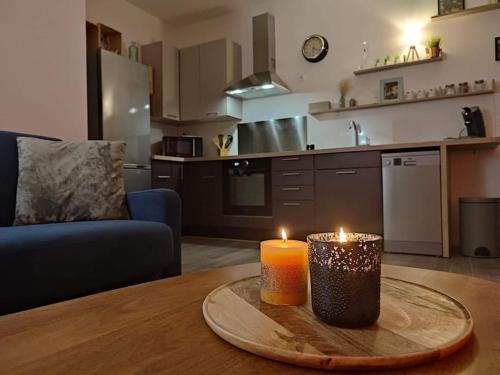 duas velas sentadas numa mesa numa cozinha em Appartement cosy au pied des Halles,Le Rossini em Narbona