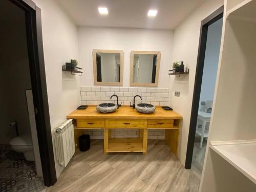 ein Bad mit einem Waschbecken und 2 Spiegeln in der Unterkunft Apto. entero. Nuevo y muy cómodo in El Escorial