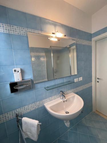 y baño con lavabo y espejo. en Appartamenti HERA, en Lazise