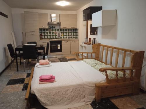 a bedroom with a large bed and a kitchen at La casa sul farfa in Bocchignano