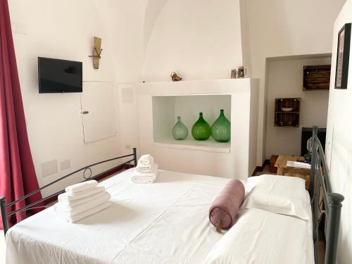 Villaggio RestaにあるMasseria Vicoの壁に緑の花瓶が敷かれた病院のベッド