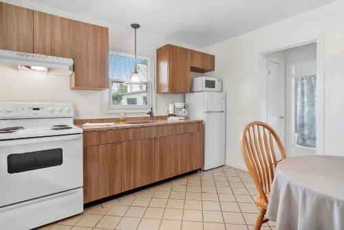 a kitchen with a white stove top oven next to a table at Carlin's Cottage Court in Calistoga