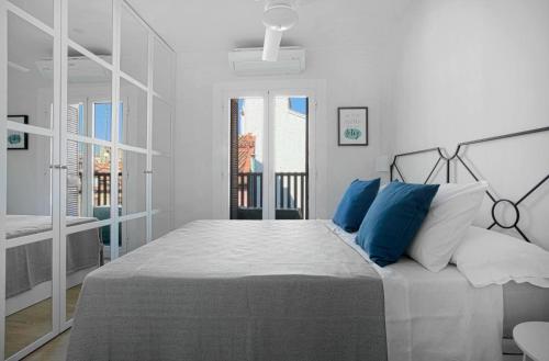 マドリードにあるGenteel Home Cava Bajaの白いベッドルーム(青い枕の大型ベッド付)