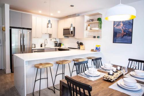 a kitchen and dining room with a table and chairs at The Shred Shack - Stylish Revelstoke Condo in Revelstoke