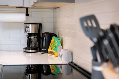 a counter in a kitchen with a coffee maker at The Shred Shack - Stylish Revelstoke Condo in Revelstoke