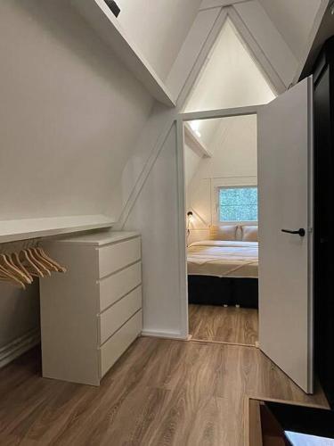 a attic bedroom with a bed and a window at Gezellige Caban in de natuur in Lanaken