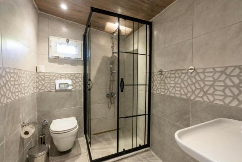 een badkamer met een douche, een toilet en een wastafel bij Atlas Han Hotel in Istanbul