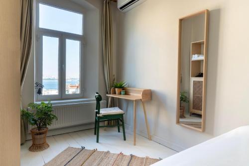 een slaapkamer met een bureau en een raam bij Atlas Han Hotel in Istanbul
