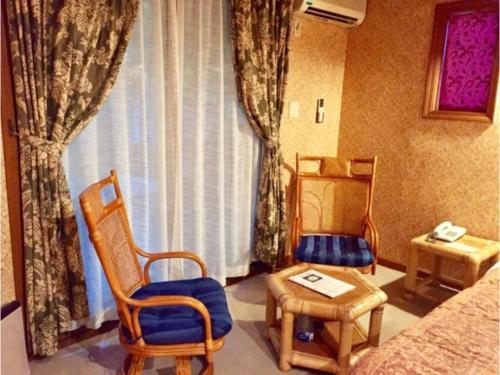 Zimmer mit 2 Stühlen, einem Tisch und einem Fenster in der Unterkunft Estivant Club - Vacation STAY 95695v in Tsumagoi