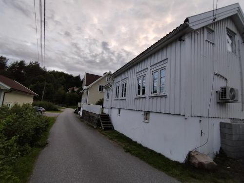 um edifício branco na berma de uma estrada em Sørlandshus med 3 soverom em Arendal