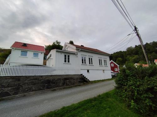 ein weißes Haus am Straßenrand in der Unterkunft Sørlandshus med 3 soverom in Arendal