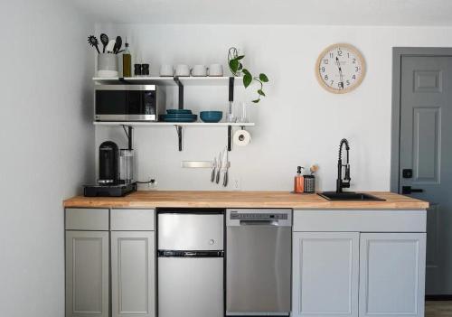 cocina con armarios blancos y encimera de madera en Northbank Loft en Springfield