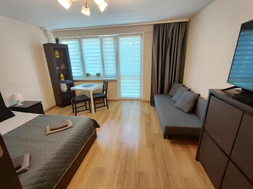 Zimmer mit einem Bett, einem Sofa und einem Tisch in der Unterkunft Top Apartamenty Centrum - Rondo ONZ in Warschau