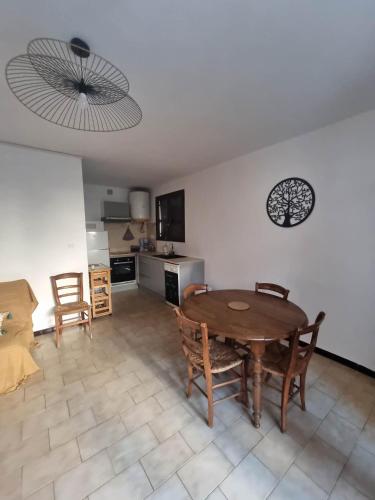 cocina y comedor con mesa y sillas en Appartement avec jardin proche de la mer, en Valras-Plage