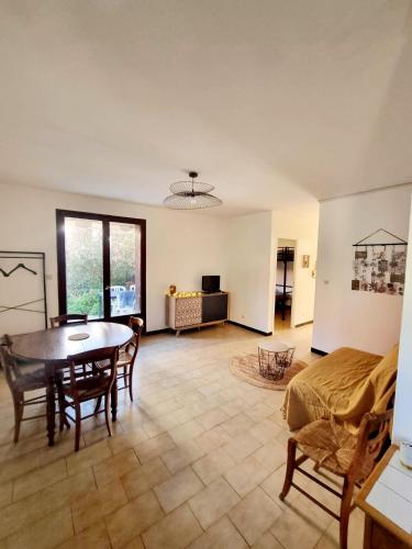 un salon avec une table et un canapé dans l'établissement Appartement avec jardin proche de la mer, à Valras-Plage