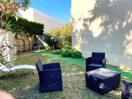un grupo de sillas sentadas al lado de un edificio en Appartement avec jardin proche de la mer, en Valras-Plage