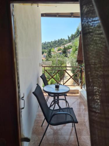 einen Tisch und Stühle auf einem Balkon mit Aussicht in der Unterkunft Este Luxury Apartments in Kriopigi