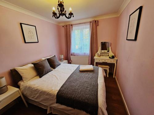 a bedroom with a bed and a desk and a window at Lovely Flat close to Shepherd's Bush in London