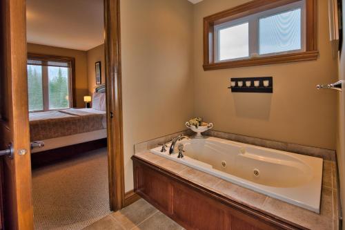 a bathroom with a tub and a bedroom at Rabaska by Rendez-Vous Mont-Tremblant in Mont-Tremblant