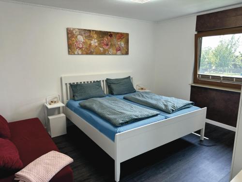 a bedroom with a bed with blue sheets and a window at URLAUB mit HUND -Ferienwohnung "AhriBella"- in Glowe