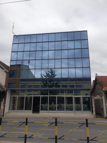 a large glass building with a tree in front of it at Magic Apartments 2 in Ub