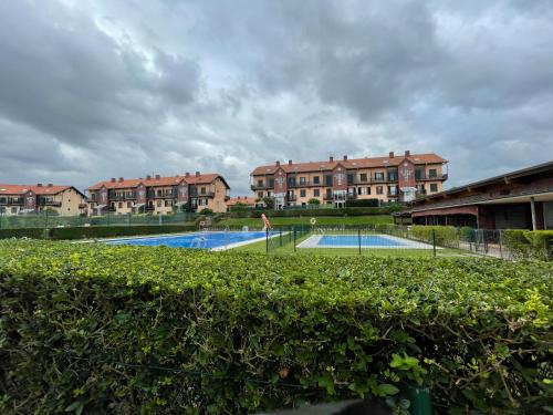 a view of a swimming pool with houses in the background at Bonito dúplex con vistas al mar in Comillas