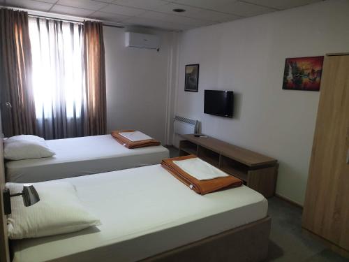 a hotel room with two beds and a television at Magic Apartments 2 in Ub