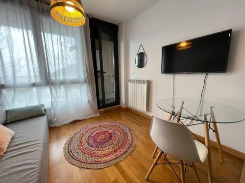 a living room with a glass table and a couch at Origen Santoña, apartamento céntrico hasta 4 plazas y fácil aparcar, opcional garaje in Santoña