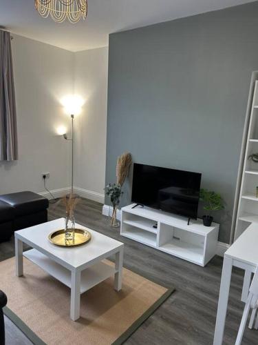 een woonkamer met een tv en een witte salontafel bij Stylish 1 bed apartment in Hull