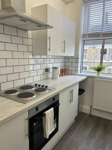 a kitchen with a stove and a counter top at Stylish 1 bed apartment in Hull
