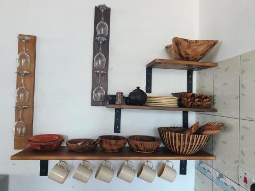 a bunch of bowls on shelves in a kitchen at Kimbi's Place in Ukunda