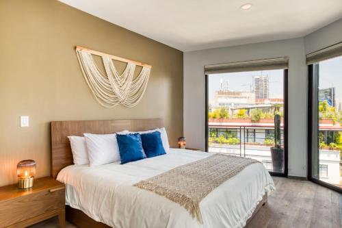 a bedroom with a large bed and a large window at Chic PH Haven with rooftop, Condesa 2BR By Tasman in Mexico City
