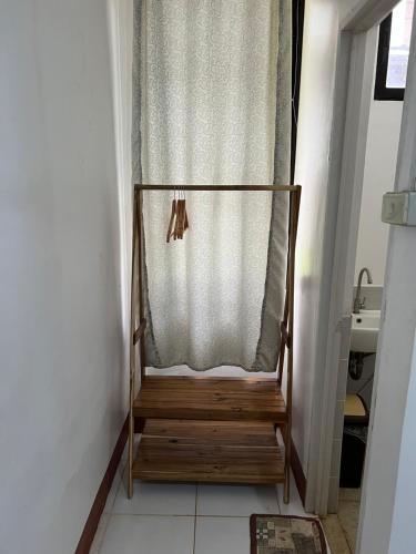 a wooden chair in a room with a curtain at Hill Myna Beach Cottages in Sabang