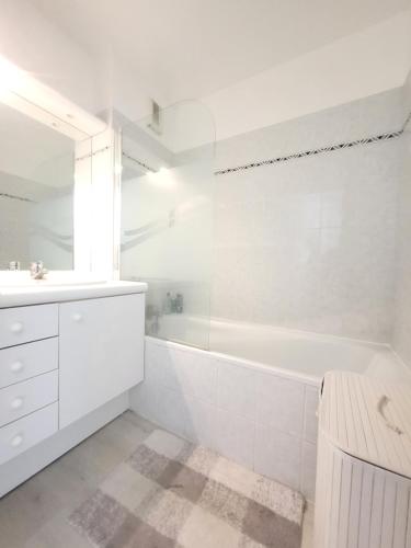 a white bathroom with a tub and a sink at Paris Eiffel tower 10min Apt for 4 people Eiffel Tower 10MIN in Issy-les-Moulineaux