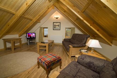 a living room with a couch and a tv at Clan Cottages Luxury Thatched Retreat near Oban in Oban