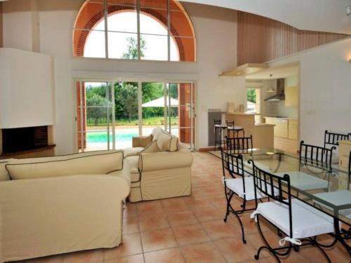 Pont-de-Larn的住宿－Villas du Golf Domaine Royal Green，带沙发和桌子的客厅以及厨房。