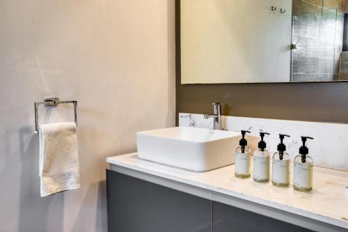 a bathroom with a sink and a counter with three bottles at Chic PH Haven with rooftop, Condesa 2BR By Tasman in Mexico City
