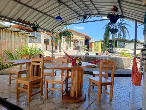 un patio con mesa y sillas bajo una pérgola en Hostería Cacique Wasi, en Puyo