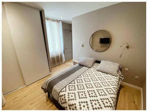 1 dormitorio con 1 cama con espejo en la pared en T 2 Calme&douceur en Tarbes