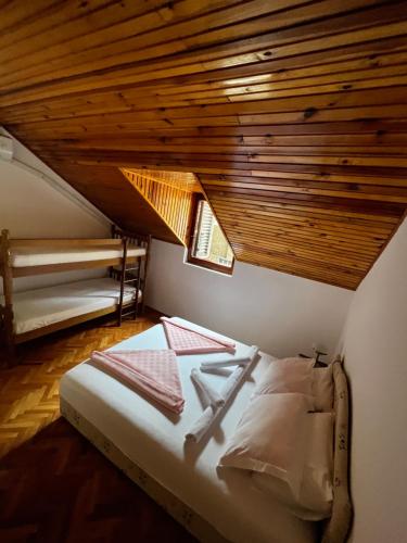 Łóżko w pokoju z drewnianym sufitem w obiekcie Villa SeaWiev w mieście Risan
