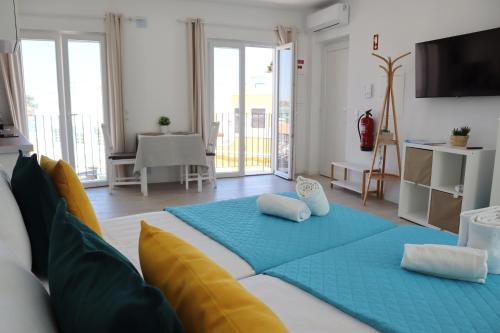 una camera da letto con un letto grande con cuscini blu di SolRia Alvor ad Alvor