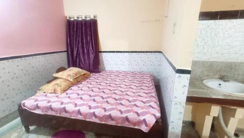 a small bedroom with a bed and a sink at Sushamalay Guest House At Sea Beach, Puri in Puri