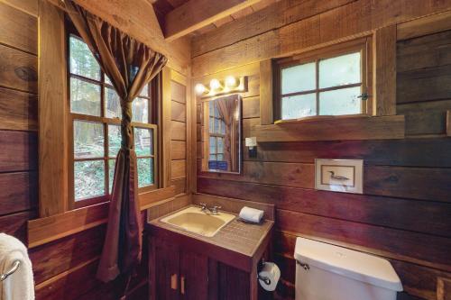 bagno con pareti in legno, lavandino e finestra di Dreamcatcher Cottage a Cazadero