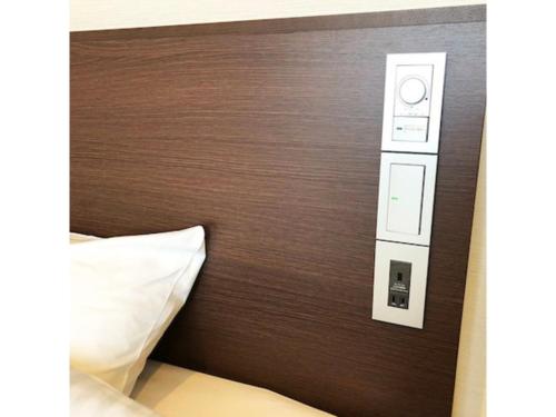 New Matto Terminal Hotel - Vacation STAY 01866v في Hakusan: اللوح الأمامي من سرير مع لوحة تحكم