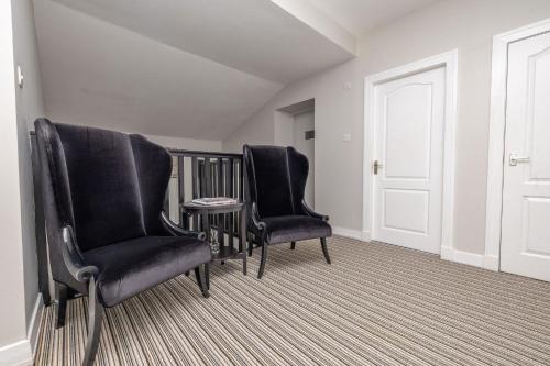 two black chairs and a table in a room at The Old Customs House in Banff