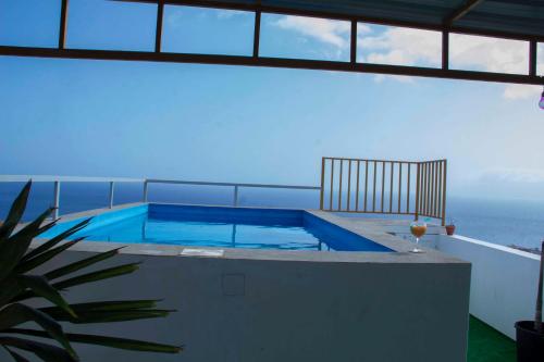 a swimming pool on top of a house with the ocean at Pipi's Guest House in São Filipe