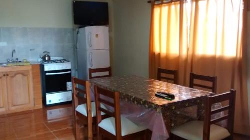 cocina con mesa con sillas y encimera en CABAÑA deMONTAÑA SANTA RITA LAS RABONAS en Las Rabonas