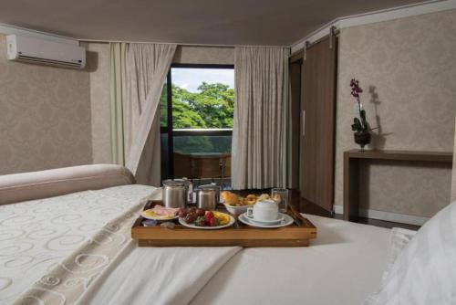 a tray of food on a bed in a hotel room at Taiwan Hotel in Ribeirão Preto